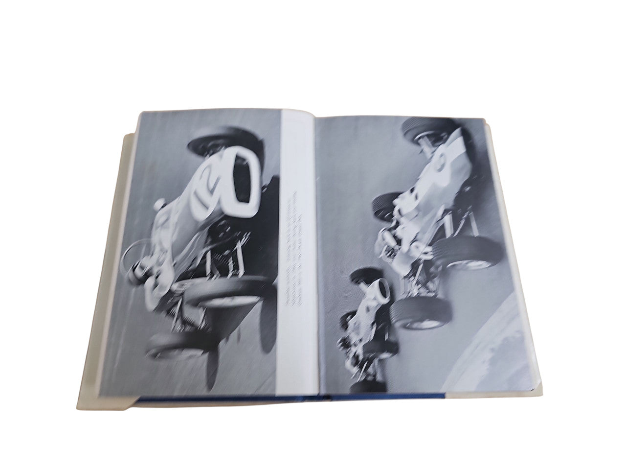 Opened motorsport book spread with two black-and-white action portraits