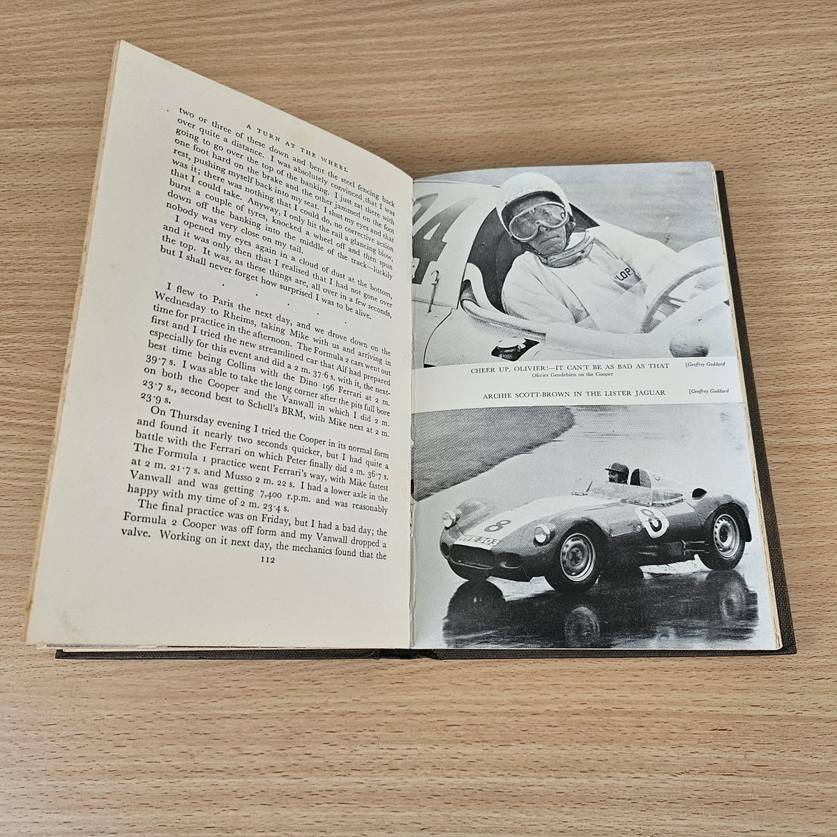 Open vintage racing book with text and black-and-white sports car action photo