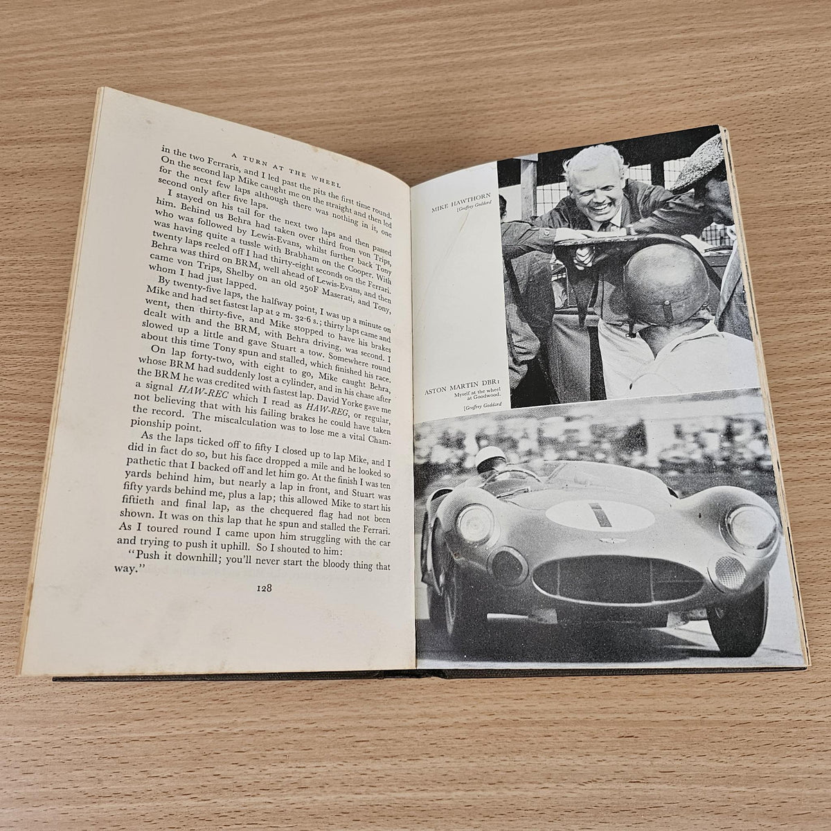 Open vintage racing book with text and large black-and-white car portrait photo