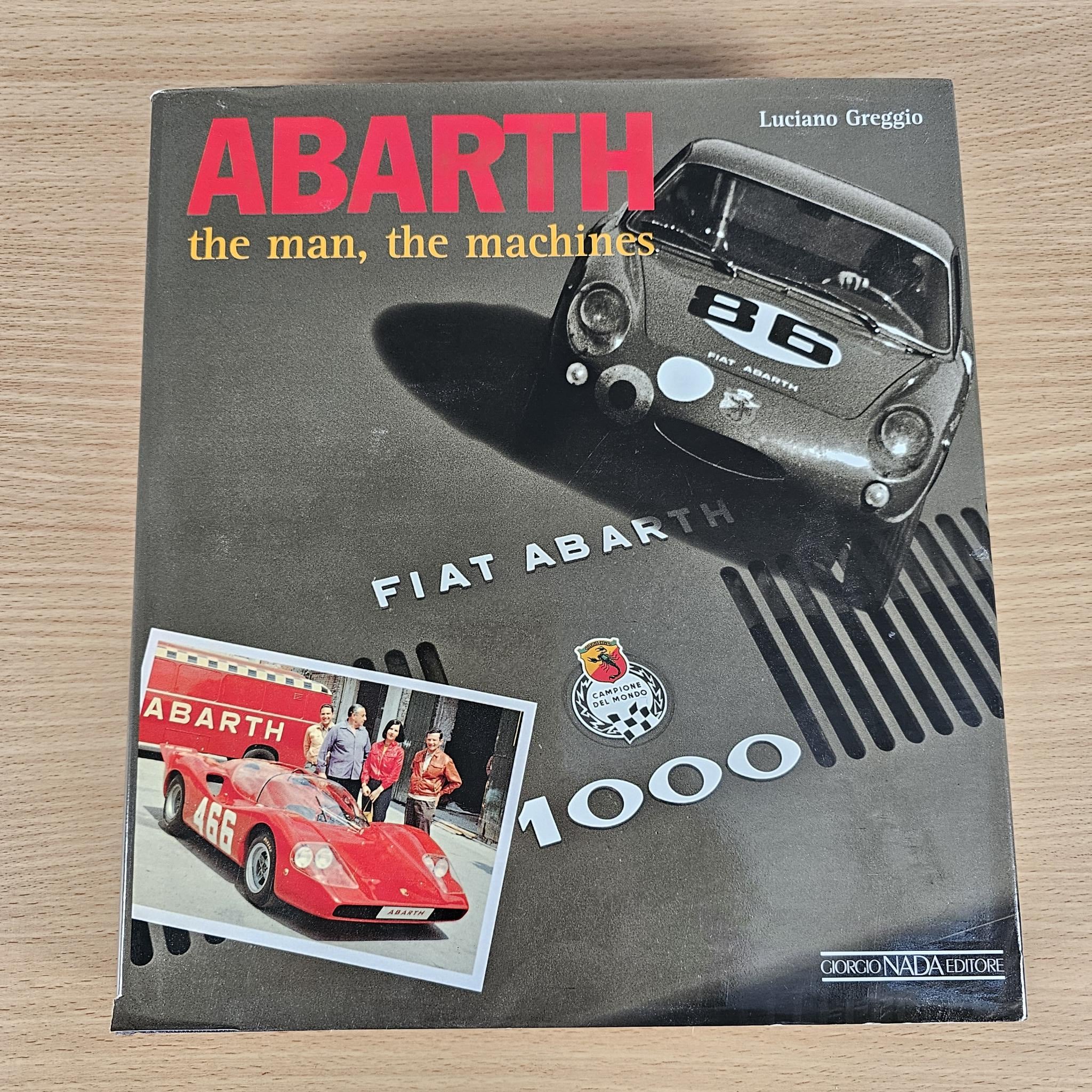 Hardcover car book with dark cover, red logo, and vintage car artwork.