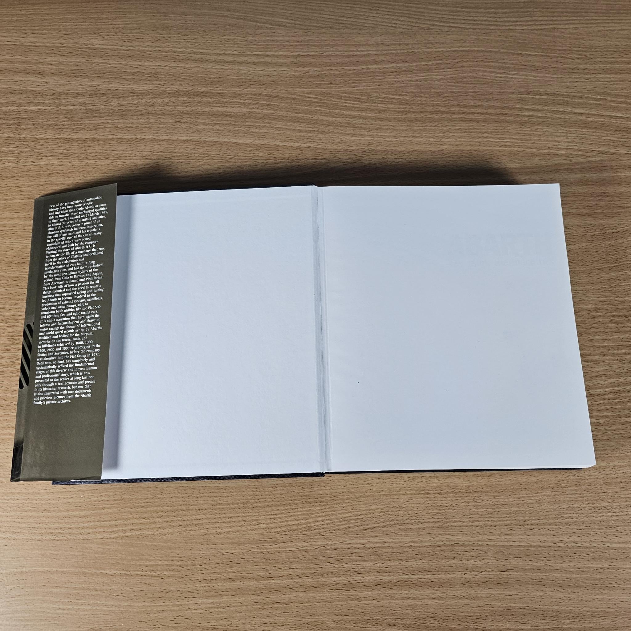 Open hardcover car book with white pages and a black spine on the left.
