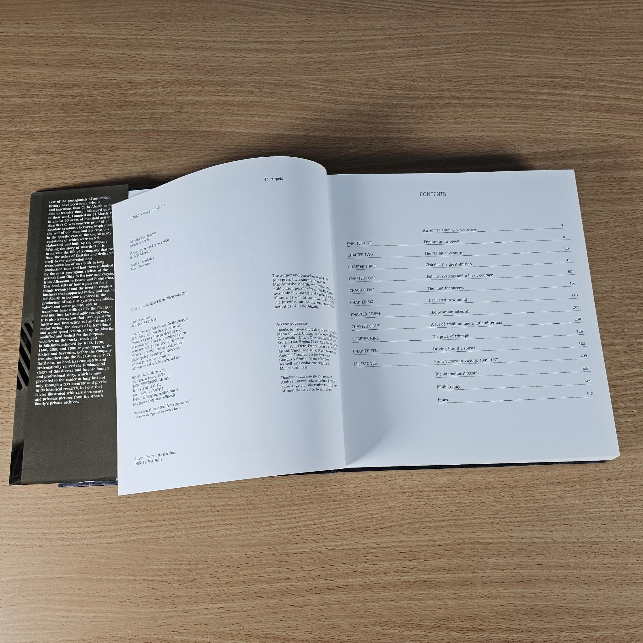 Open hardcover car book with white pages and text tables on the right.