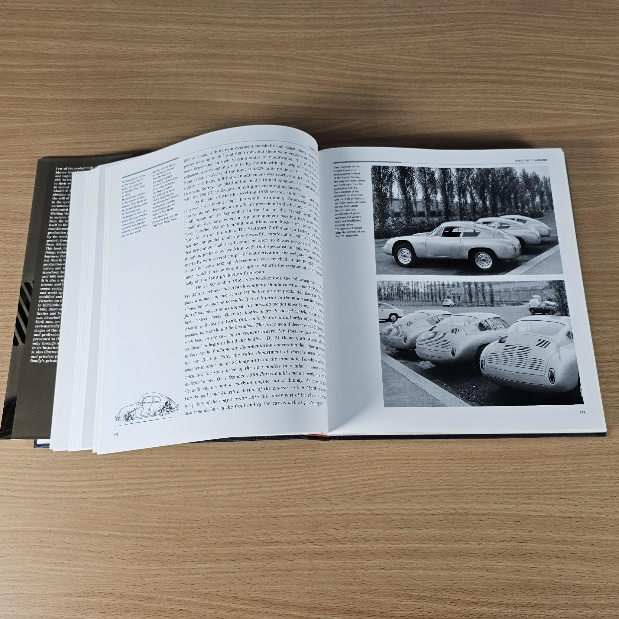 Open hardcover car book pages with black-and-white car photos and captions.