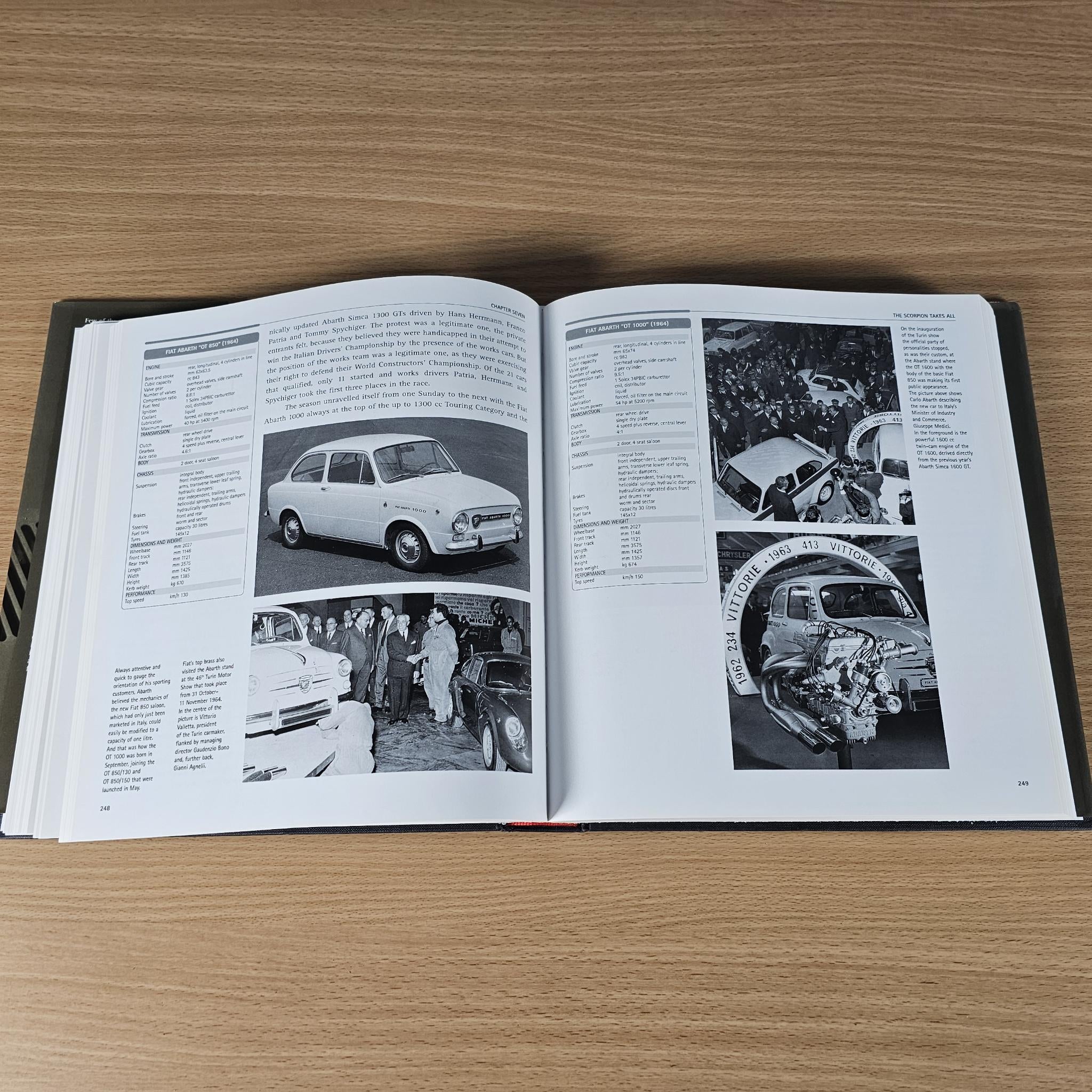 Open hardcover car book spread with car photos, charts, and captions.