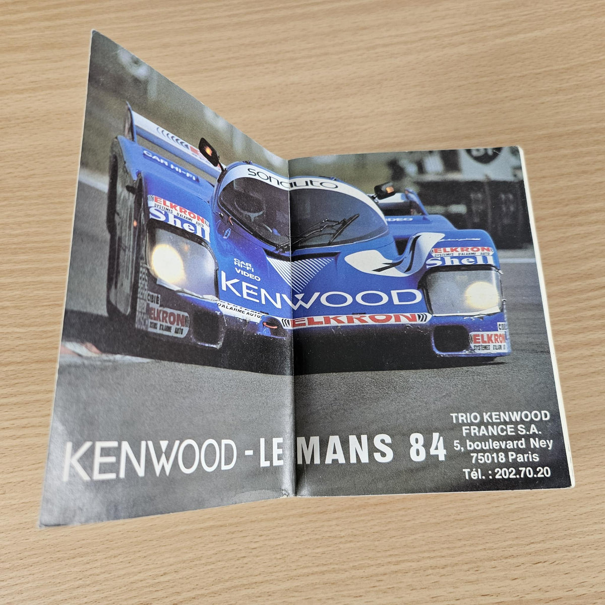 Open FIA year book spread with blue racing car photo and Kenwood-Le Mans caption.