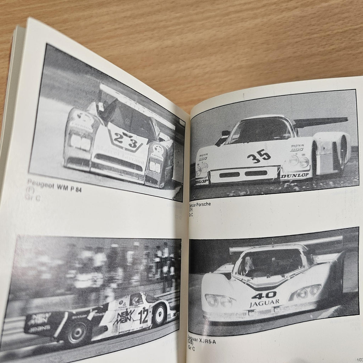 Open FIA year book spread with black-and-white race car photos and labels.