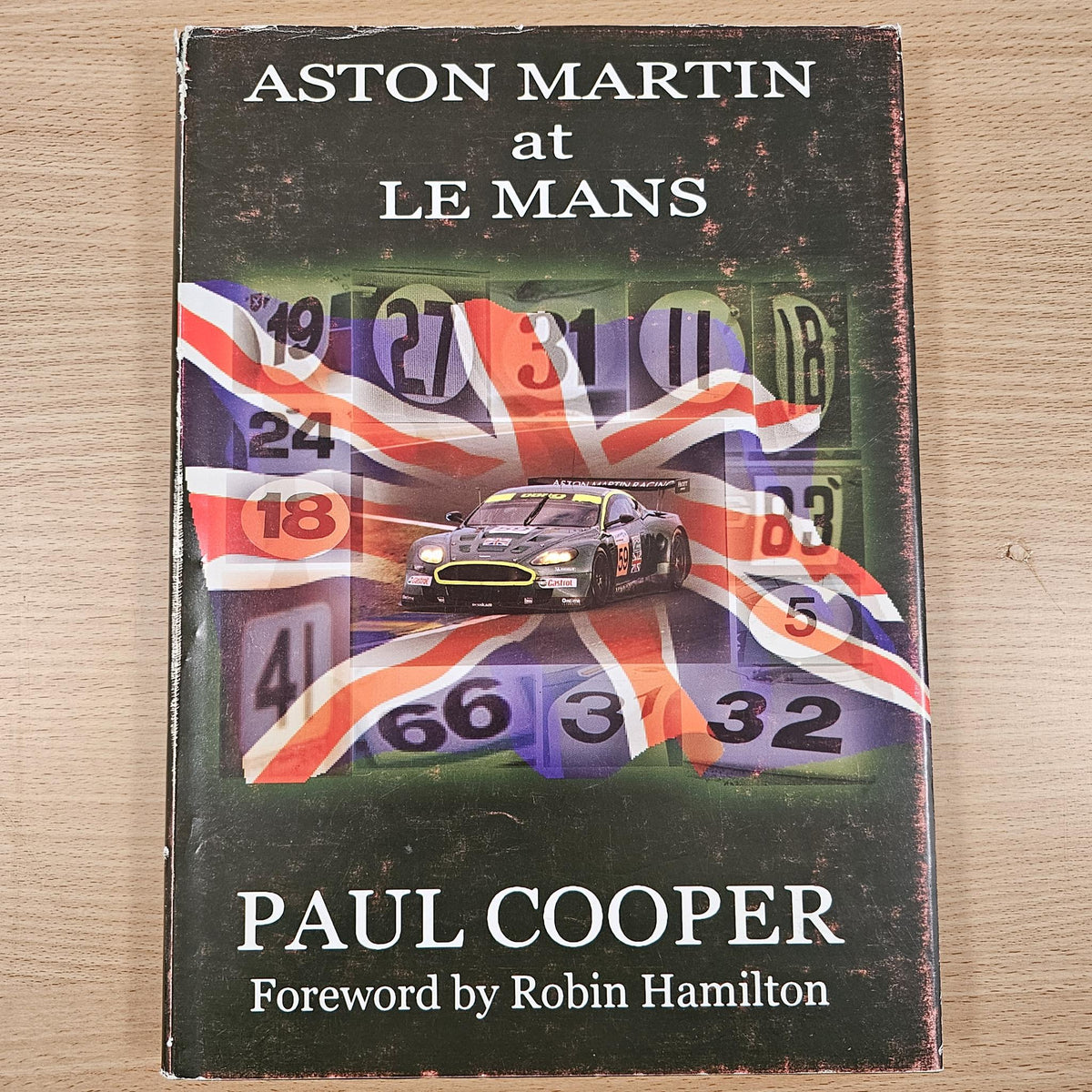 Hardcover book cover for Aston Martin at Le Mans, Paul Cooper with race car illustration