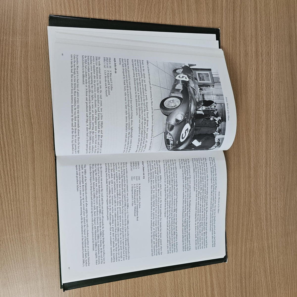 Hardcover racing book with open pages showing black-and-white car photo and text