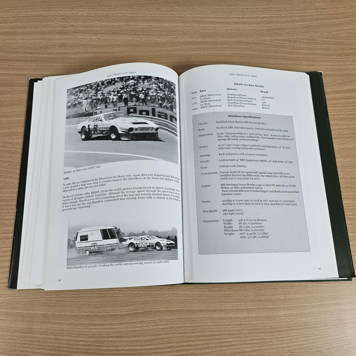 Hardcover book open to two pages with black-and-white car images and captions