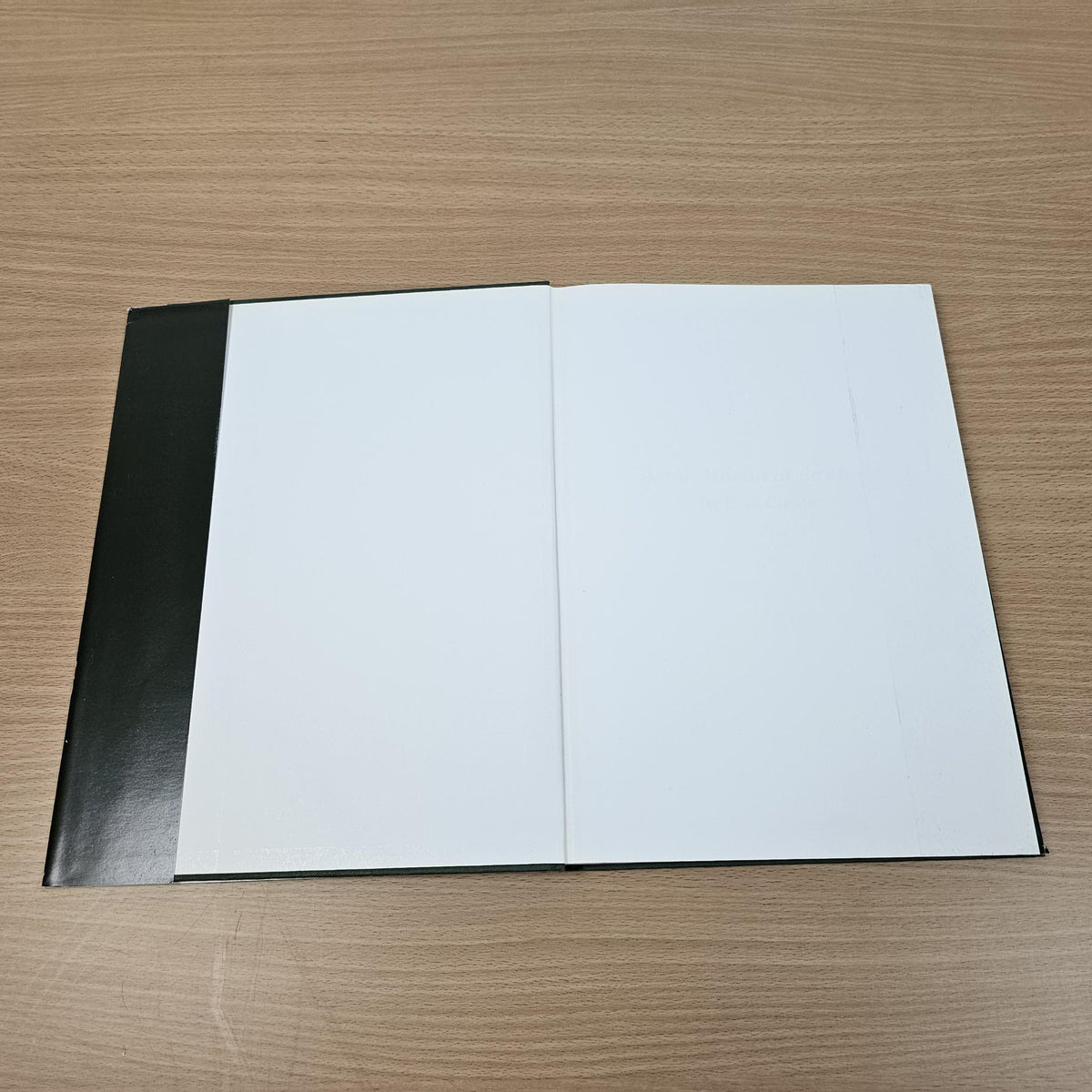 Hardcover book open flat showing two blank white pages