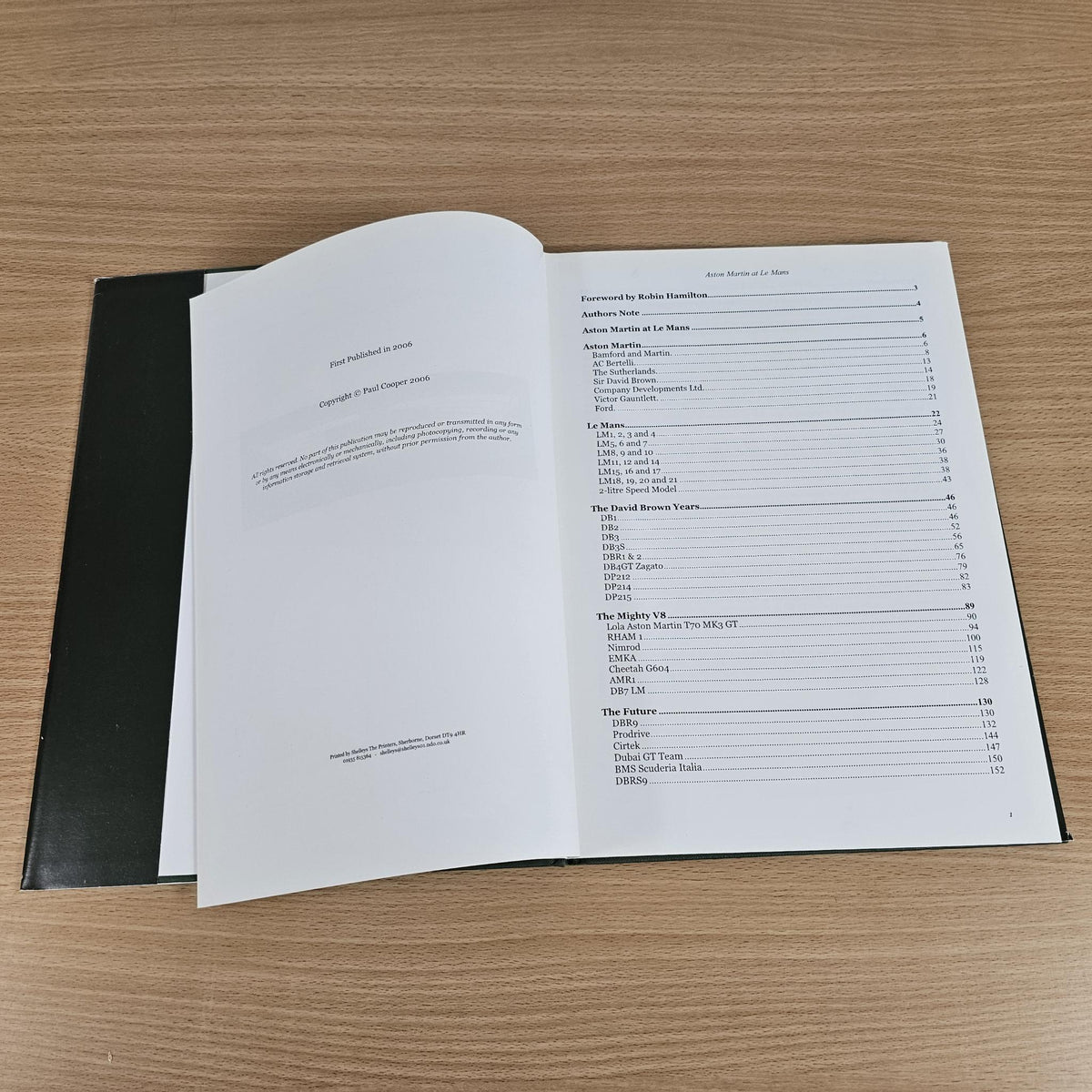 Hardcover book open to text pages with table of contents and numbered sections