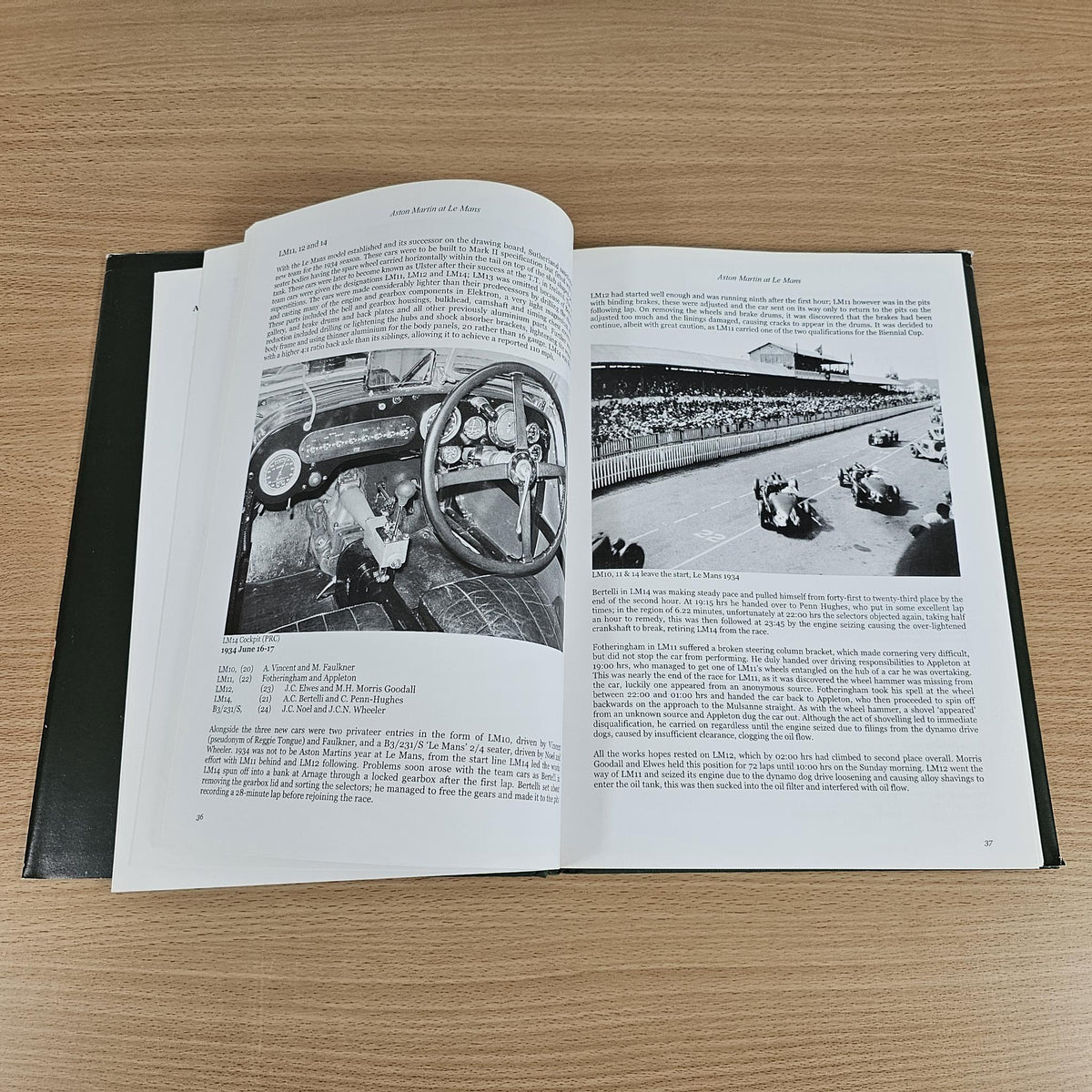 Hardcover book open to black-and-white photos, steering wheel and race track images