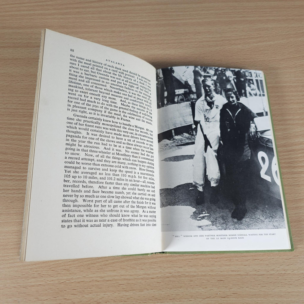Open book with text pages and black-and-white racing photo spread