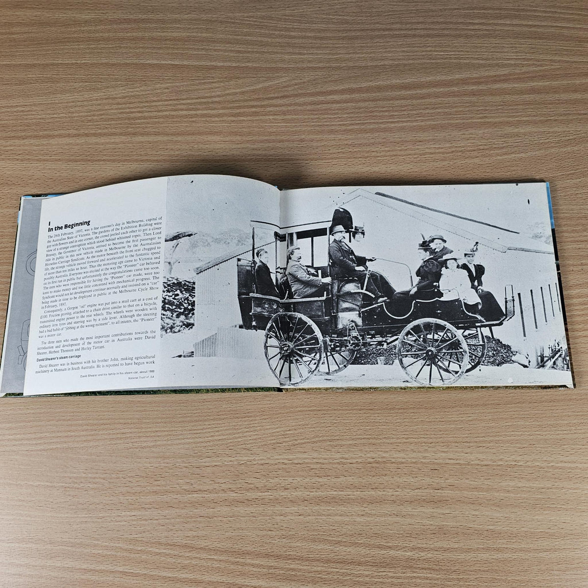 Hardcover automotive history book, open spread with black-and-white vintage car photo.