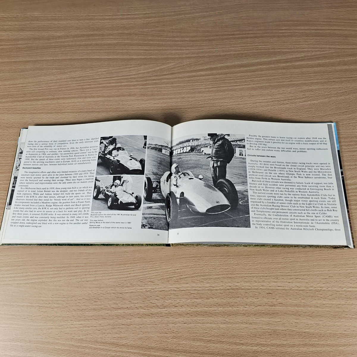 Hardcover automotive history book, open pages with black-and-white photos and captions.