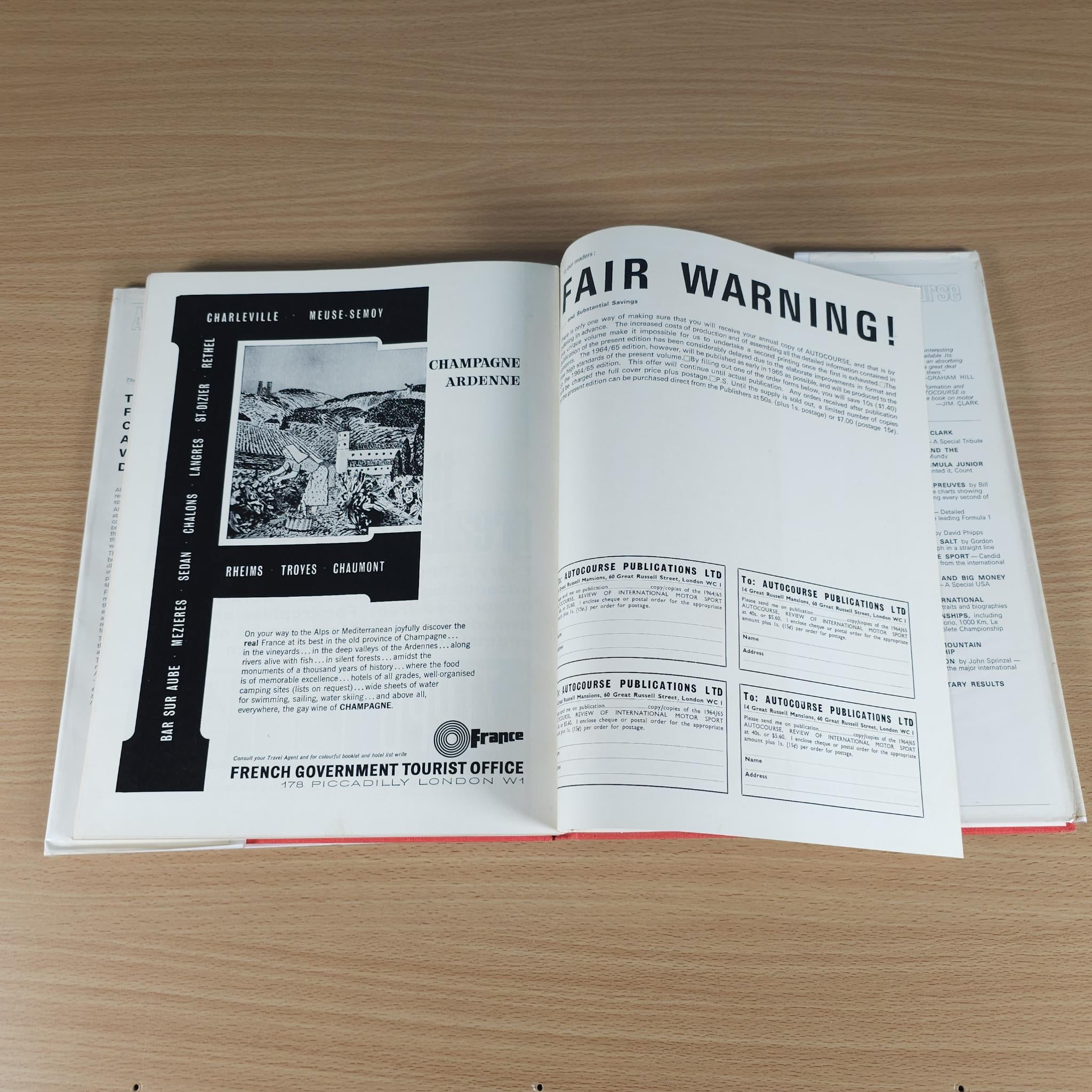 Open motorsport review book with French office ad and bold heading “FAIR WARNING!”
