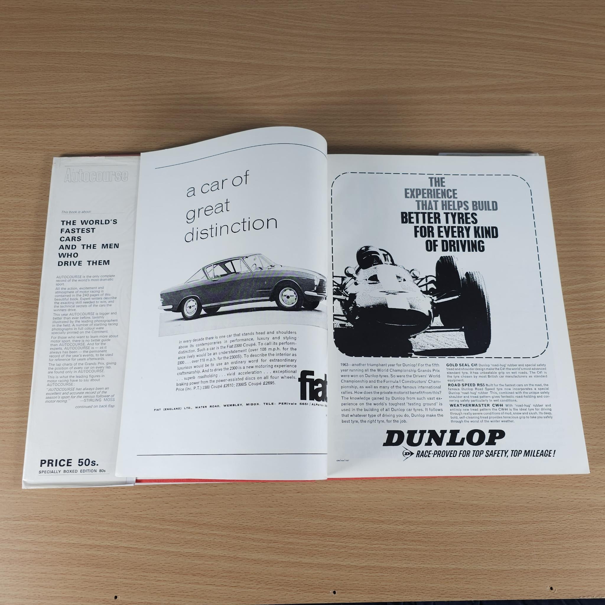 Opened motorsport book spread with car photo and “DUNLOP” advertisement page.