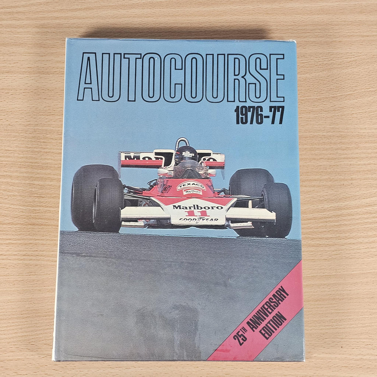 Hardcover racing annual book, blue cover with Formula car and 25th anniversary edition badge