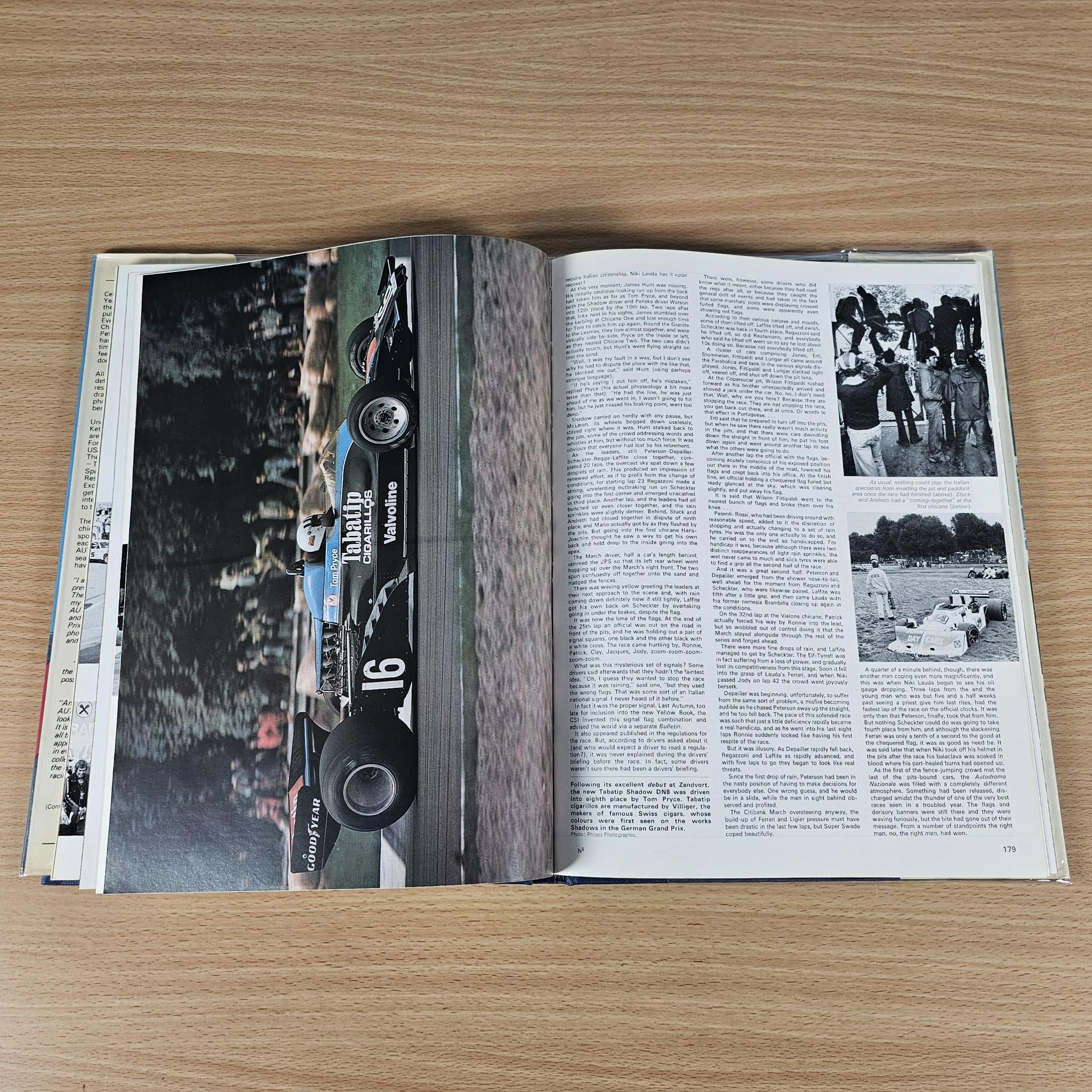 Hardcover motorsport annual, open with black-and-white race photos and article text