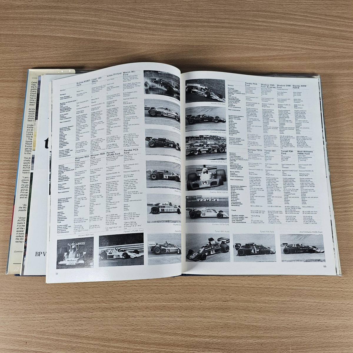 Hardcover racing annual book, open pages with race car photos and statistics tables