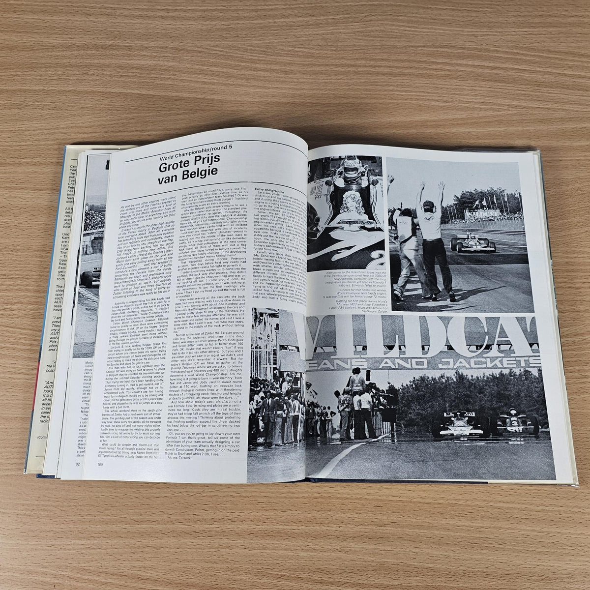 Hardcover racing annual book, open spread with text, photos, and race results graphics