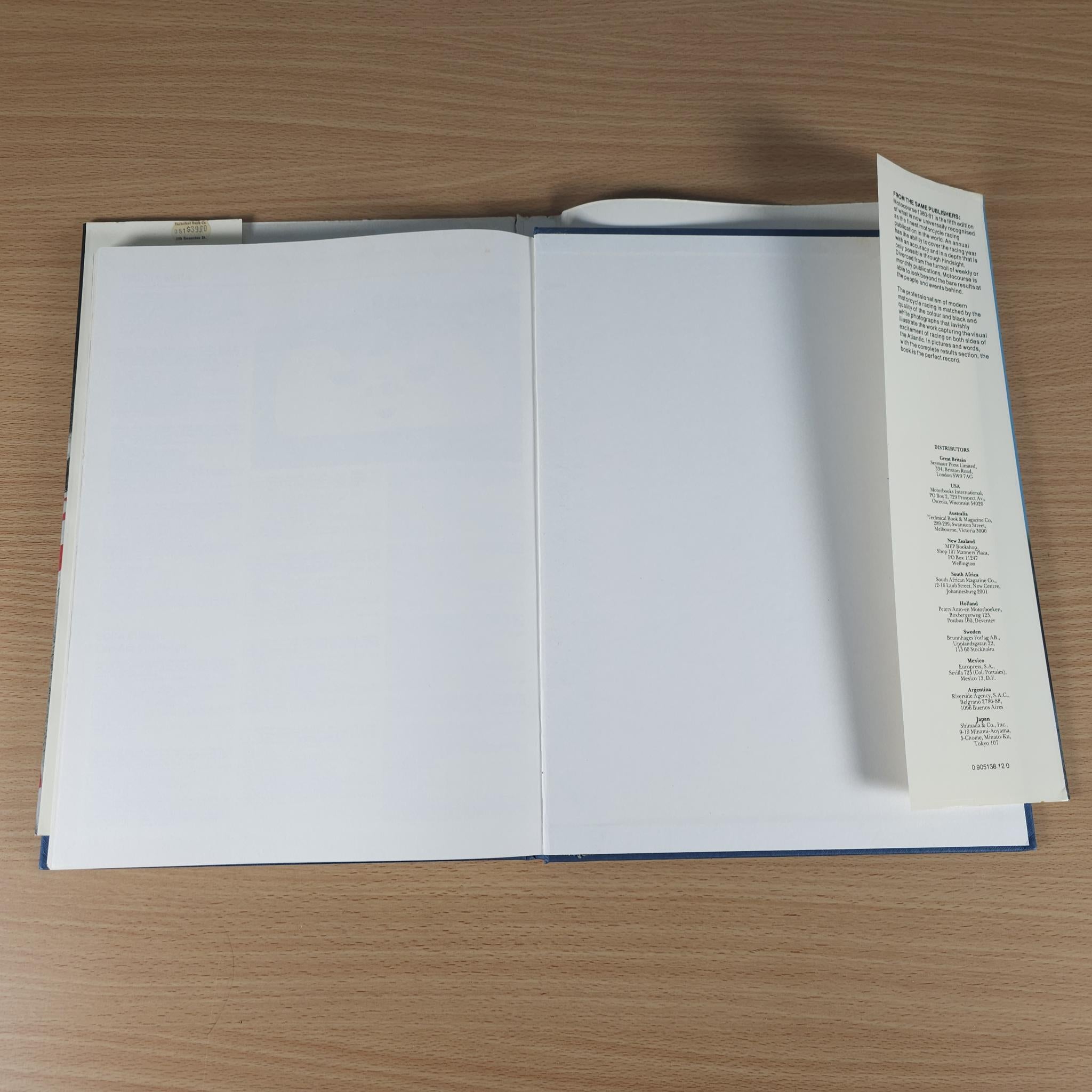 Open racing annual book with blank pages and a narrow contents leaflet