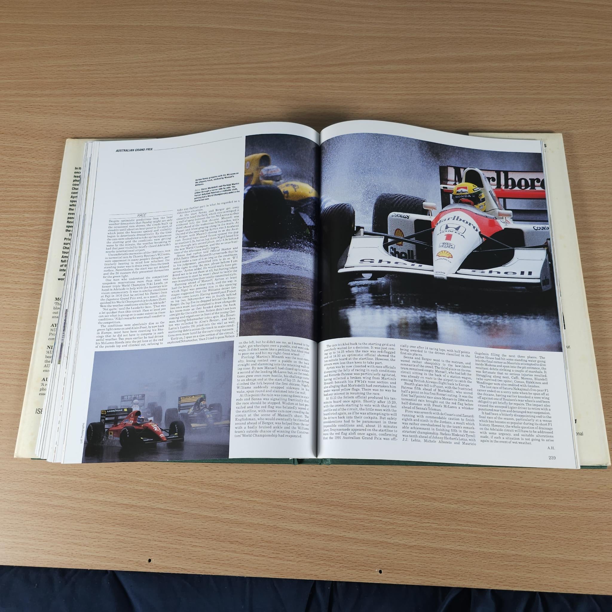 Open racing annual book with vintage race car photo and article text spread