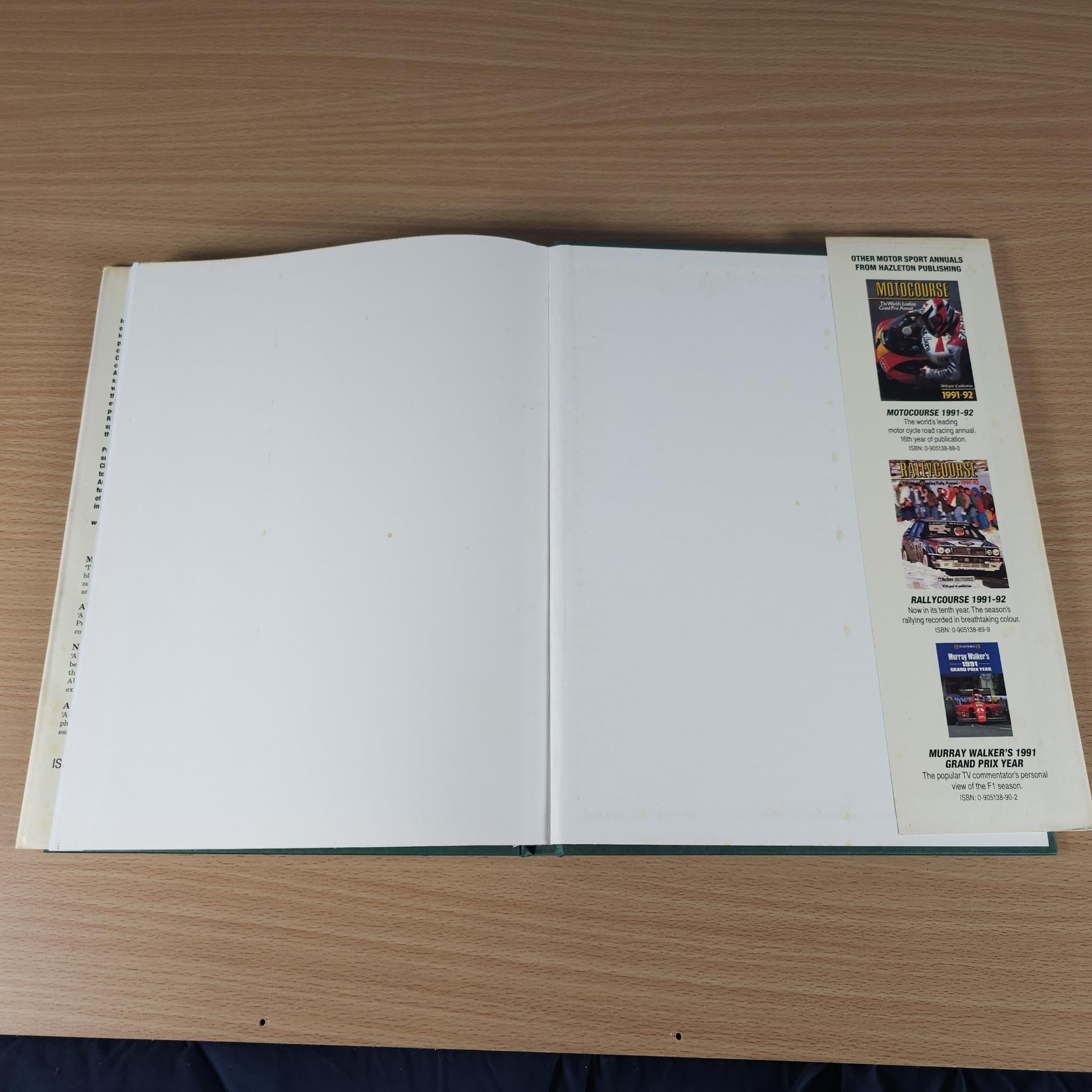 Open racing annual book with mostly blank pages and a small booklet list on right