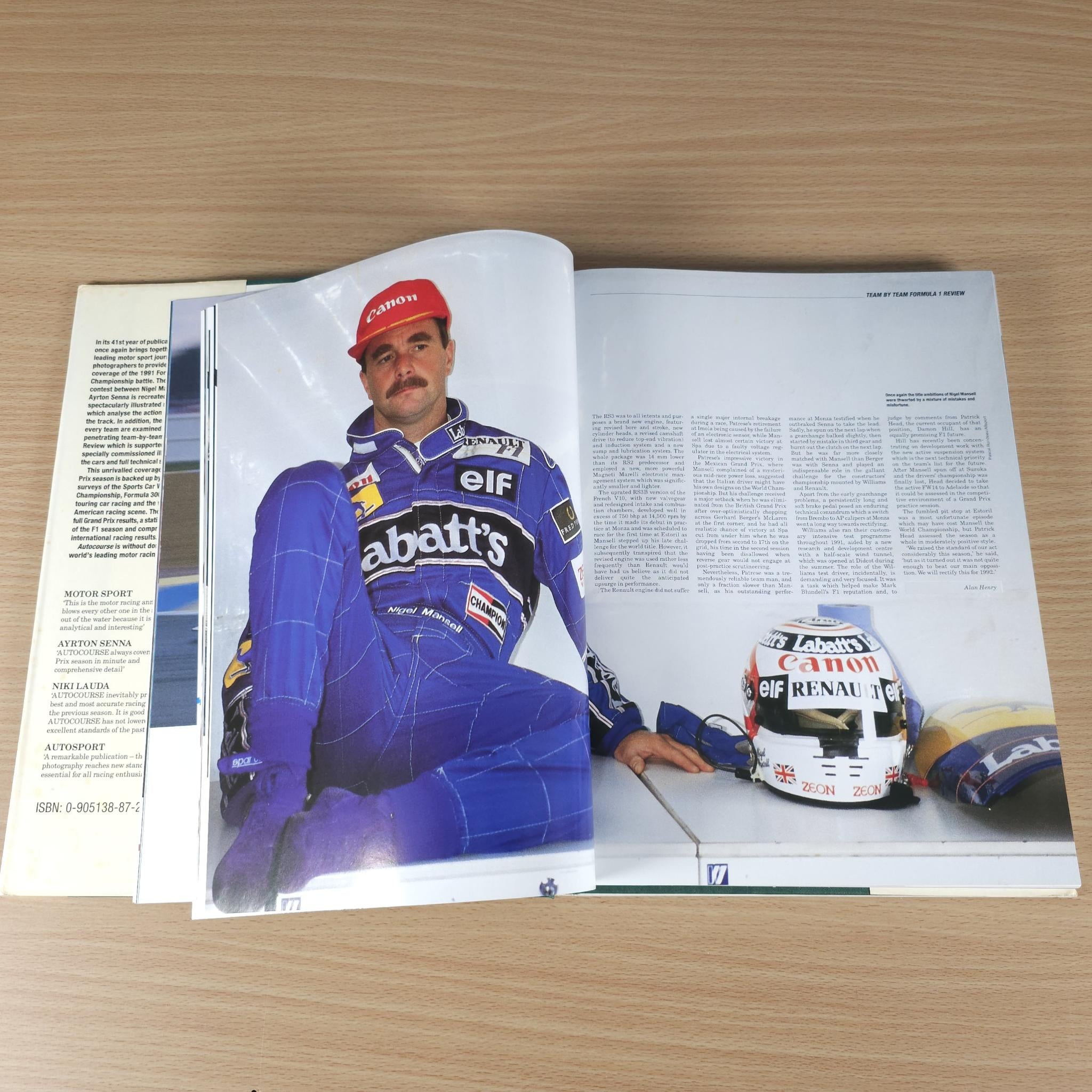 Autocourse 1991-92 book open to pages with driver portrait and helmet car photo