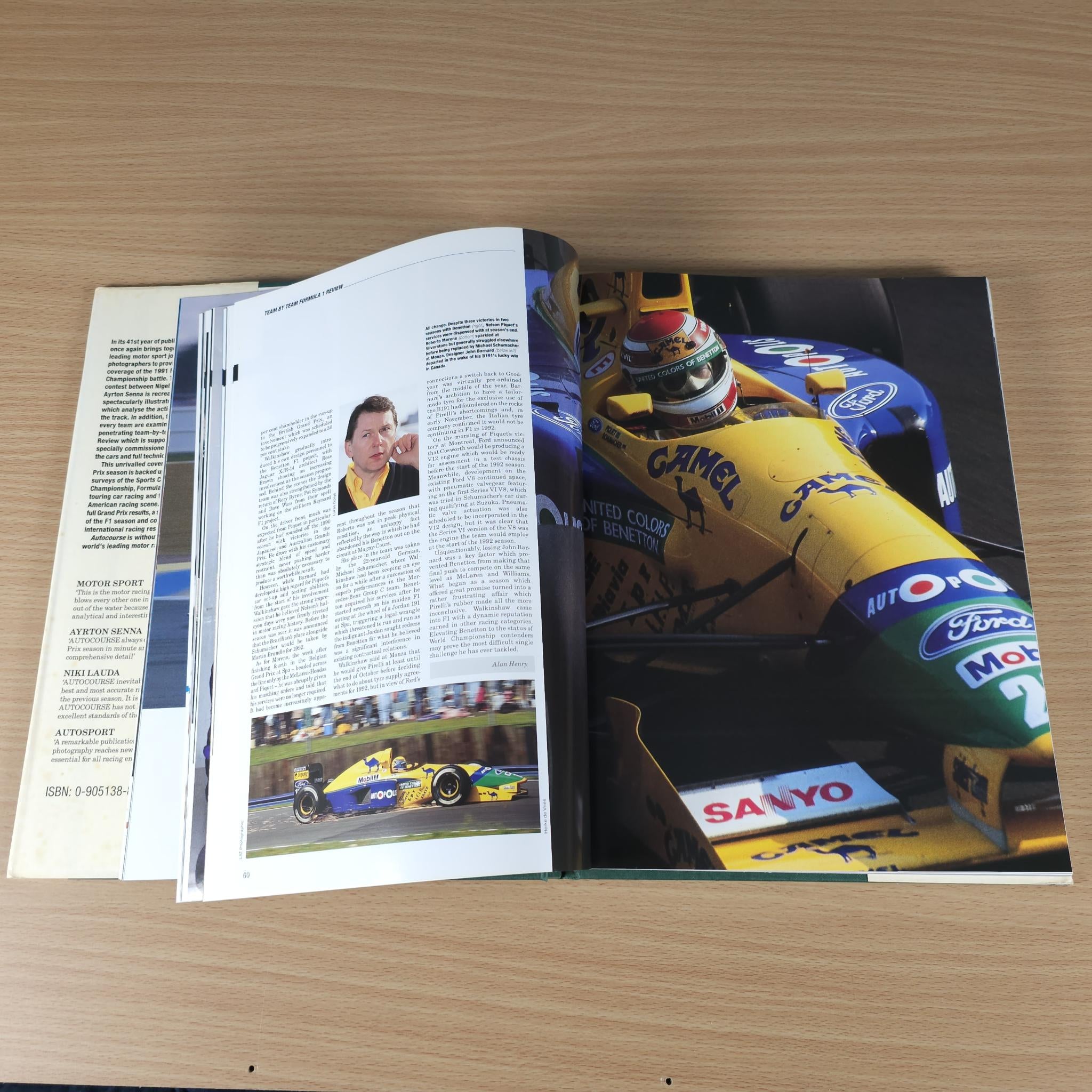 Autocourse 1991-92 book open to pages with race photos and yellow car cockpit