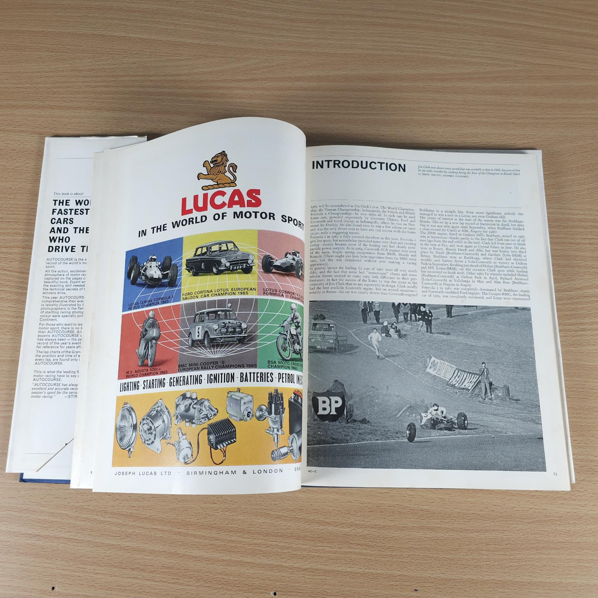 Vintage motorsport review book open to a Lucas advertisement page and introduction text