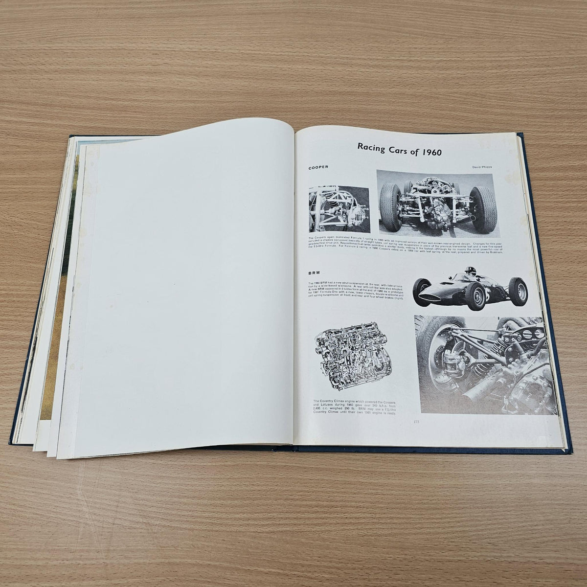 Open vintage automobile book with blank left page and engine photo details on right