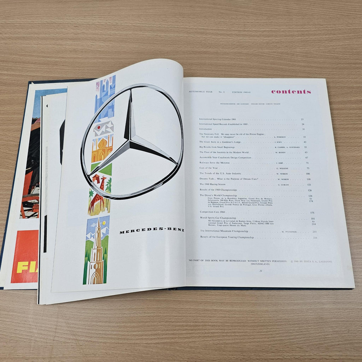 Open automobile year reference book showing Mercedes-Benz logo and printed page layout.