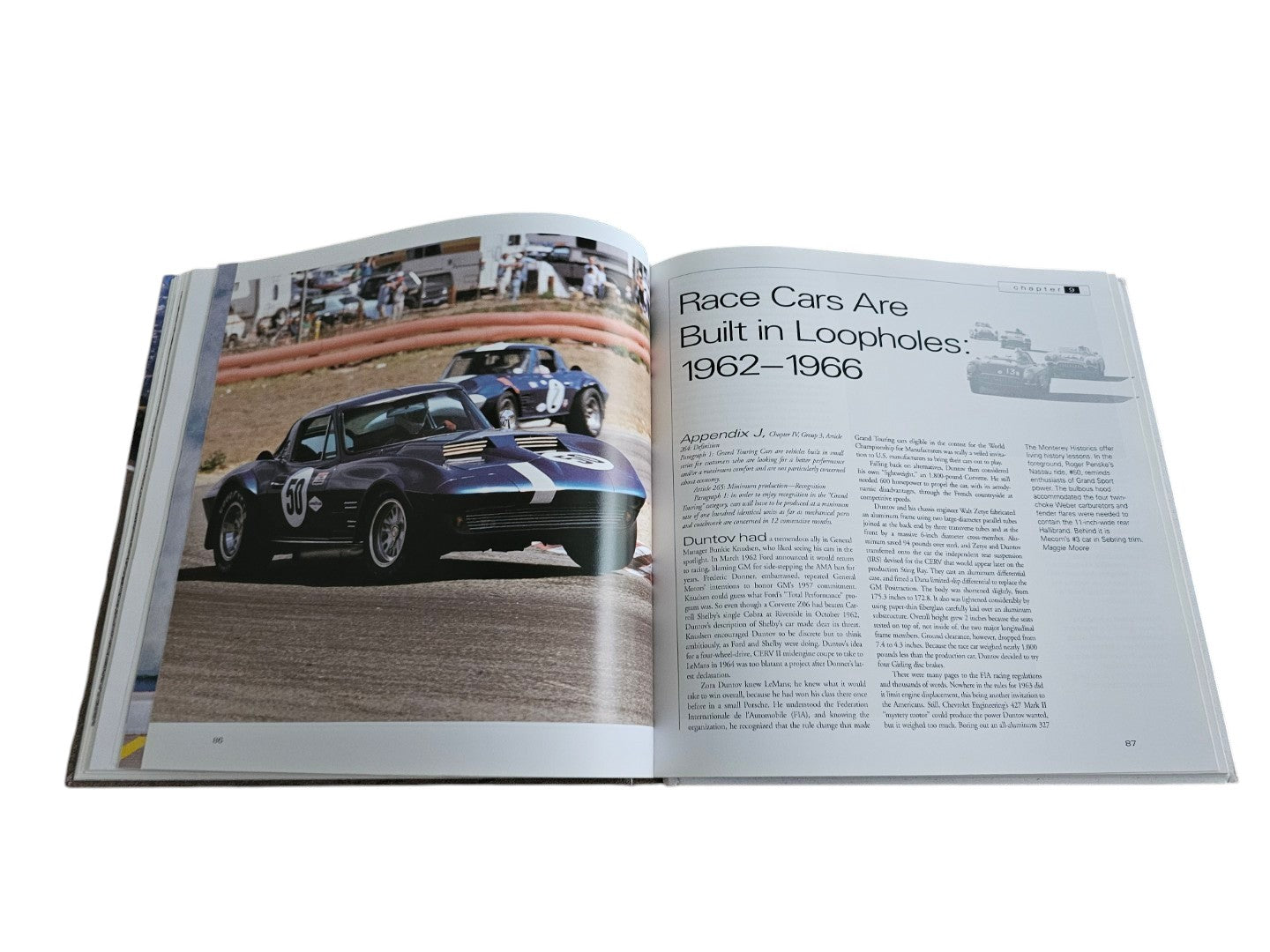 Automoto Bookshop hardcover book open to a page featuring a dark blue vintage Corvette race car on a track.