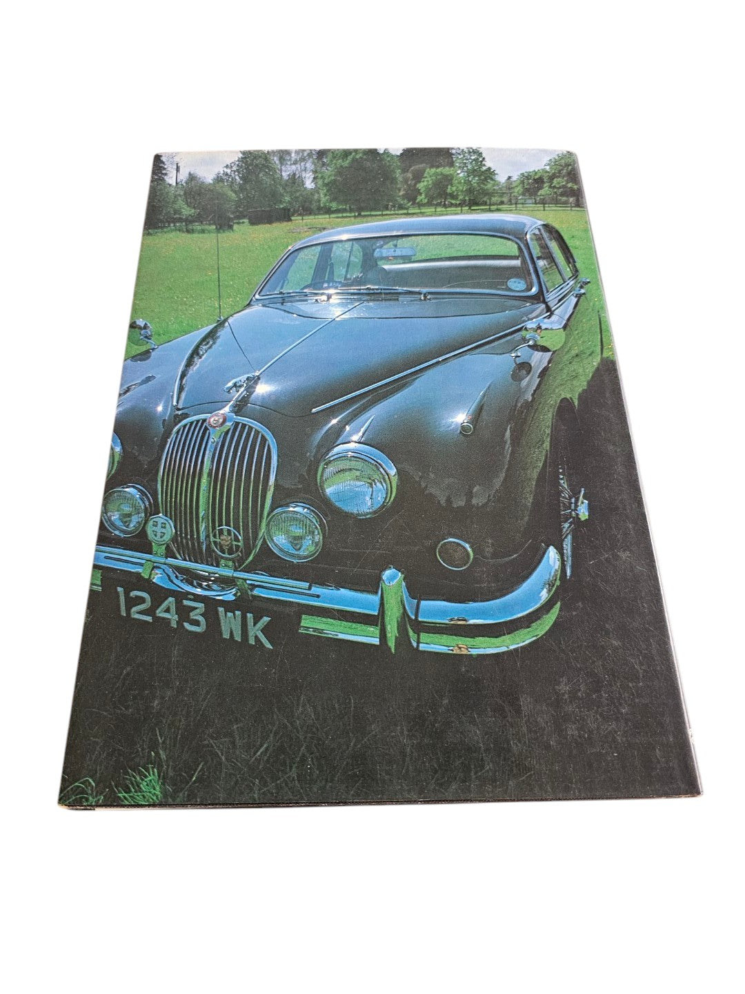 Jaguar year book cover with dark green sports car photo in angled view