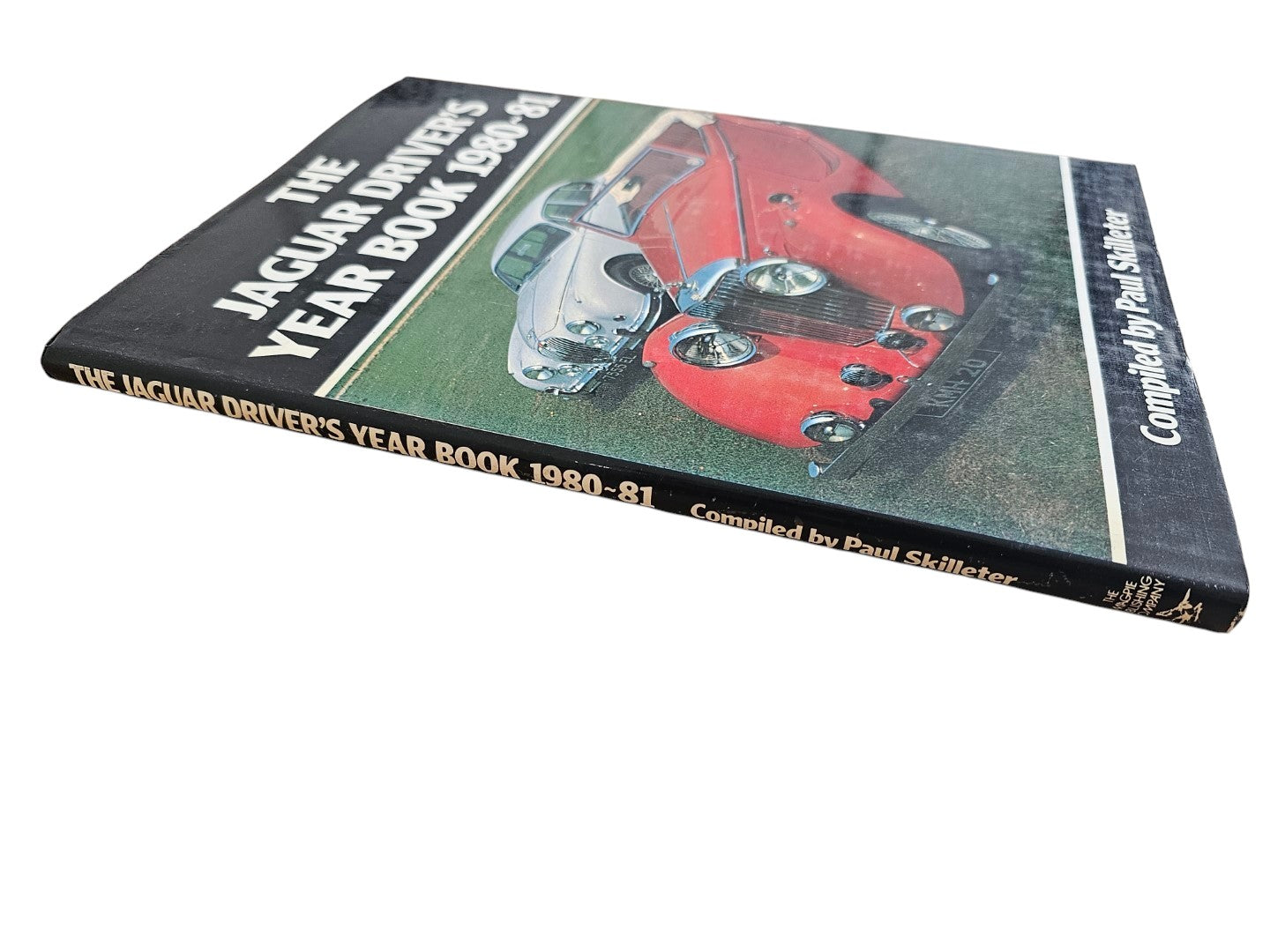 Angled Jaguar year book cover showing title text and classic car image