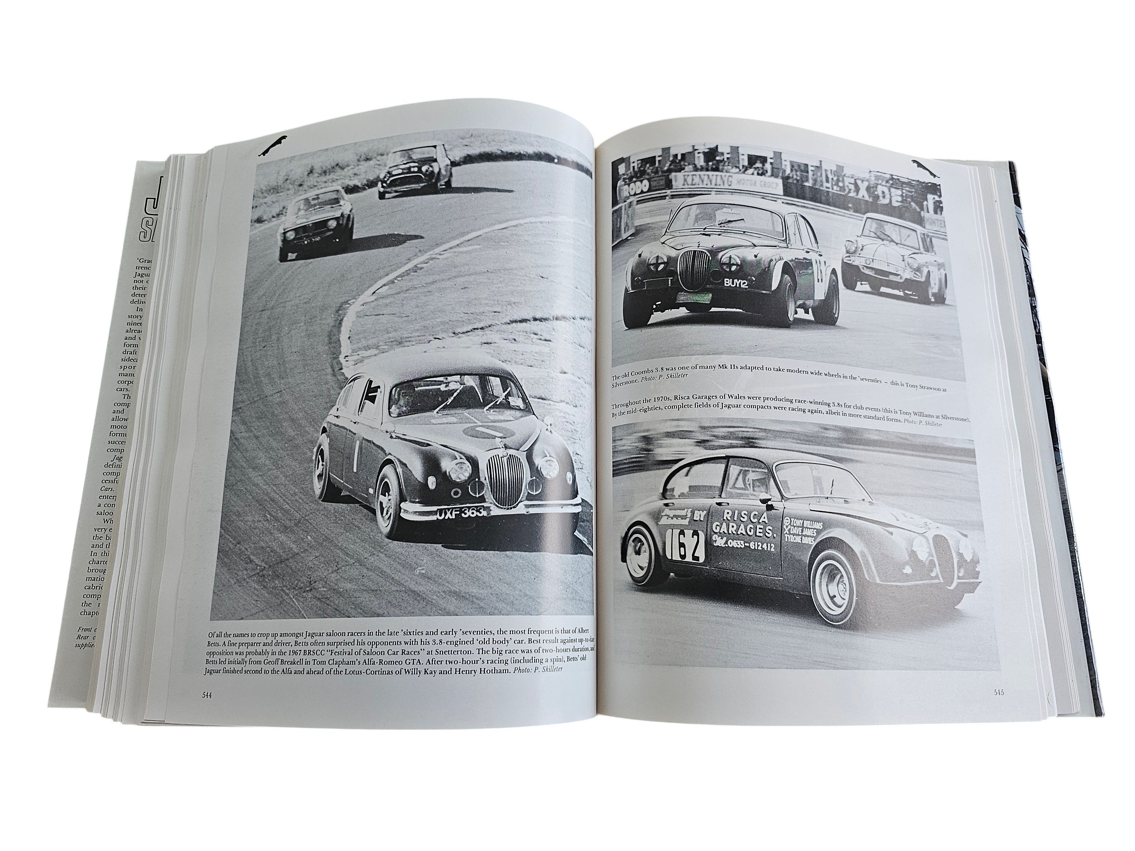 Open pages of Automoto Bookshop Jaguar Saloon Cars book featuring black and white historical racing photographs