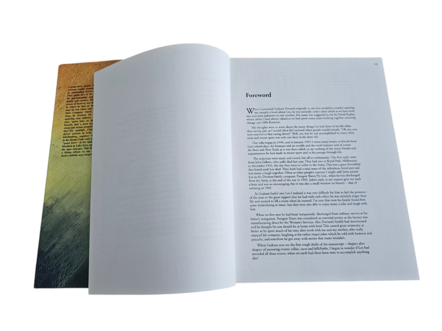 Automoto Bookshop Lex Davison Larger than Life biography book open to the foreword page on a wooden surface