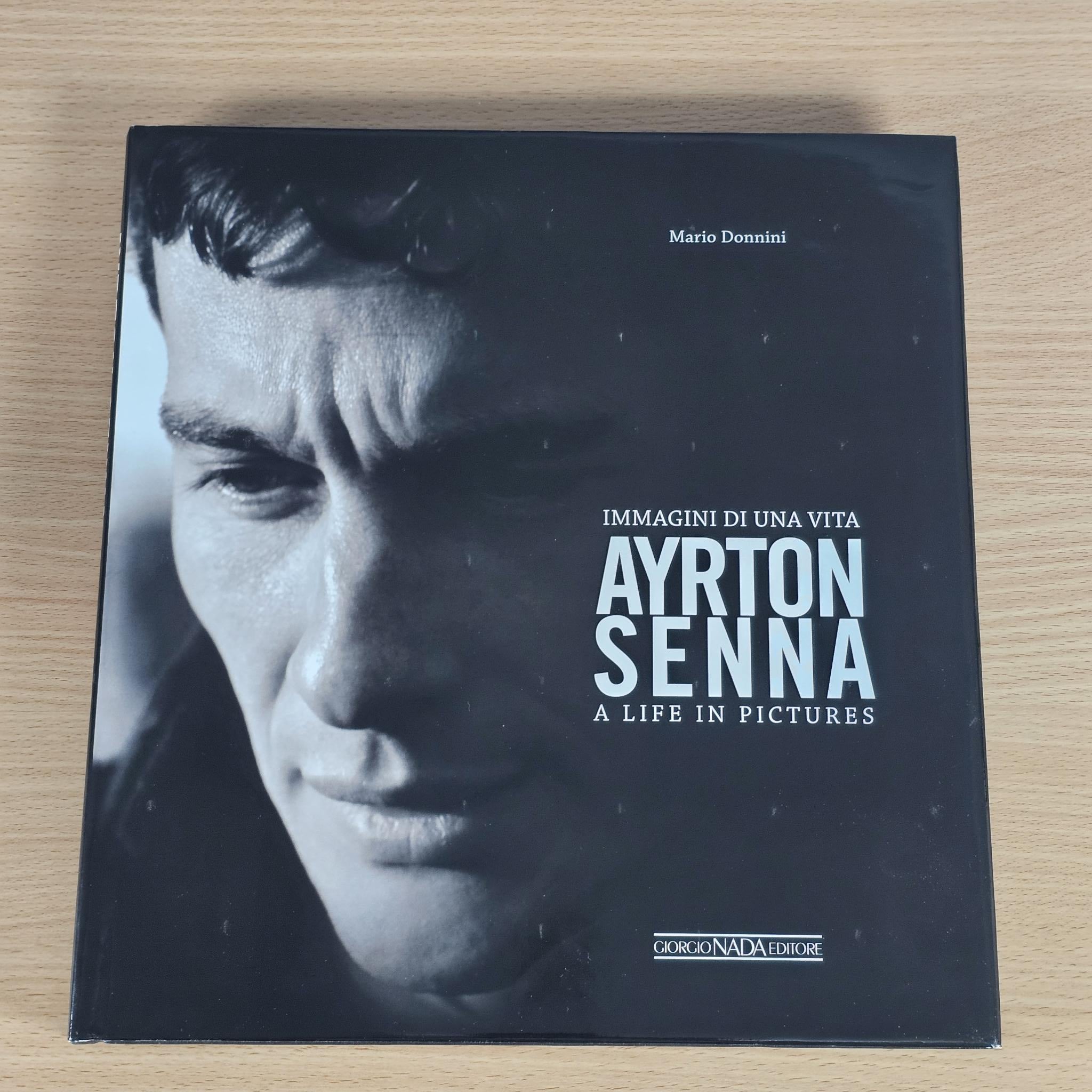 Black hardcover book with Ayrton Senna portrait on cover, titled "A Life in Pictures".