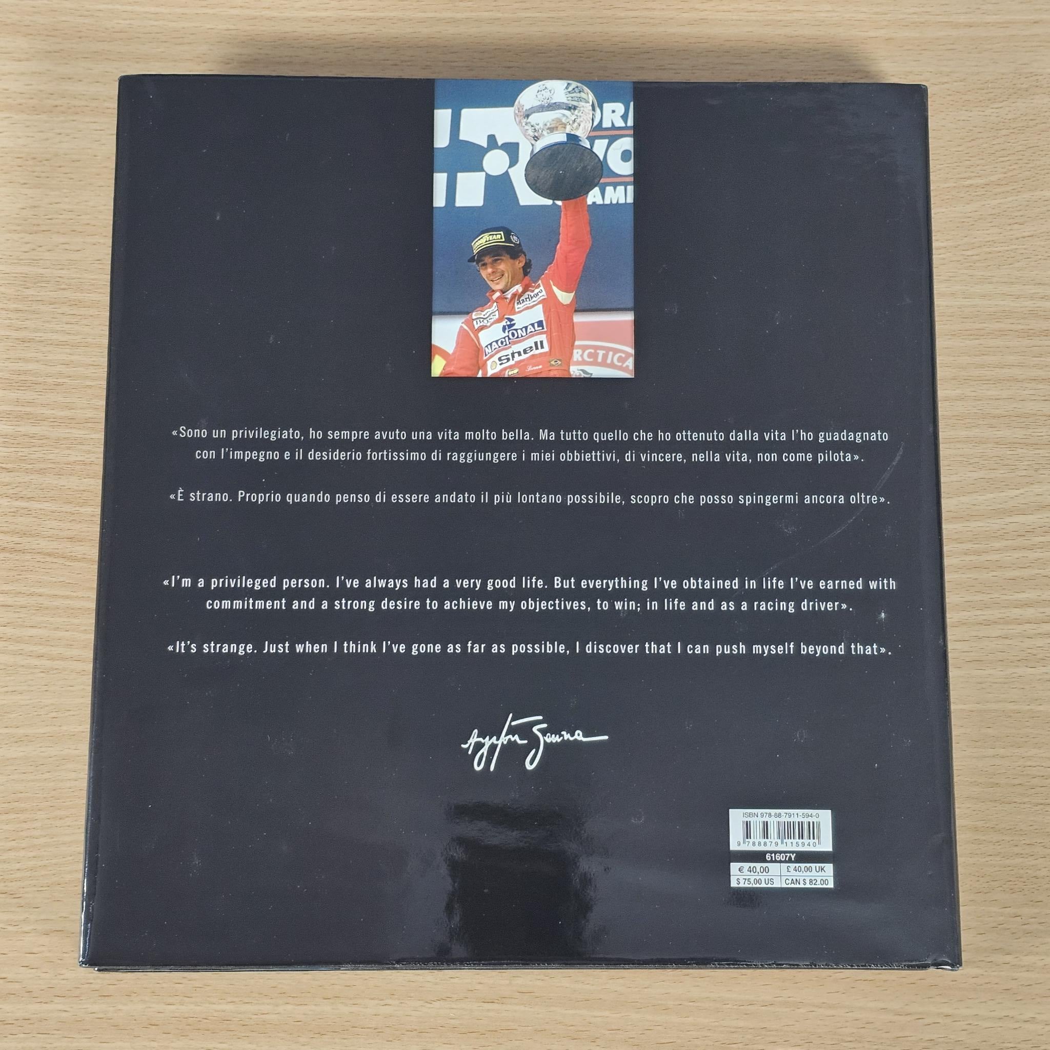 Black hardcover book back cover with author name, signature, and barcode sticker.