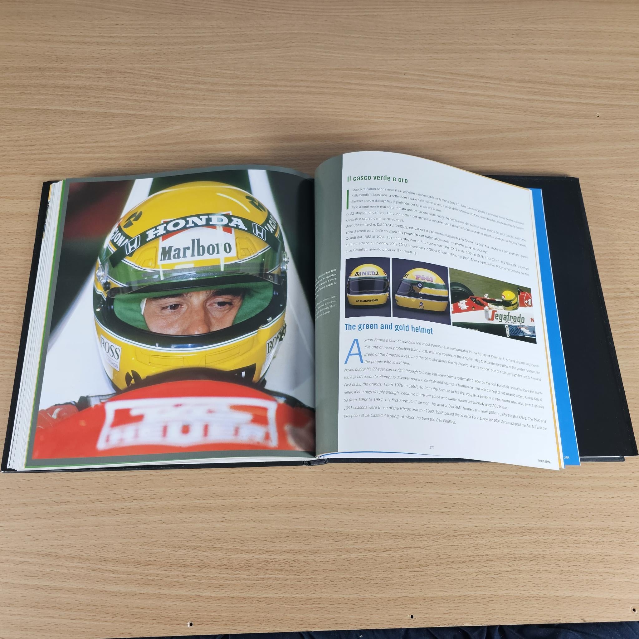 Open hardcover photo book with helmet close-up photos and printed article pages