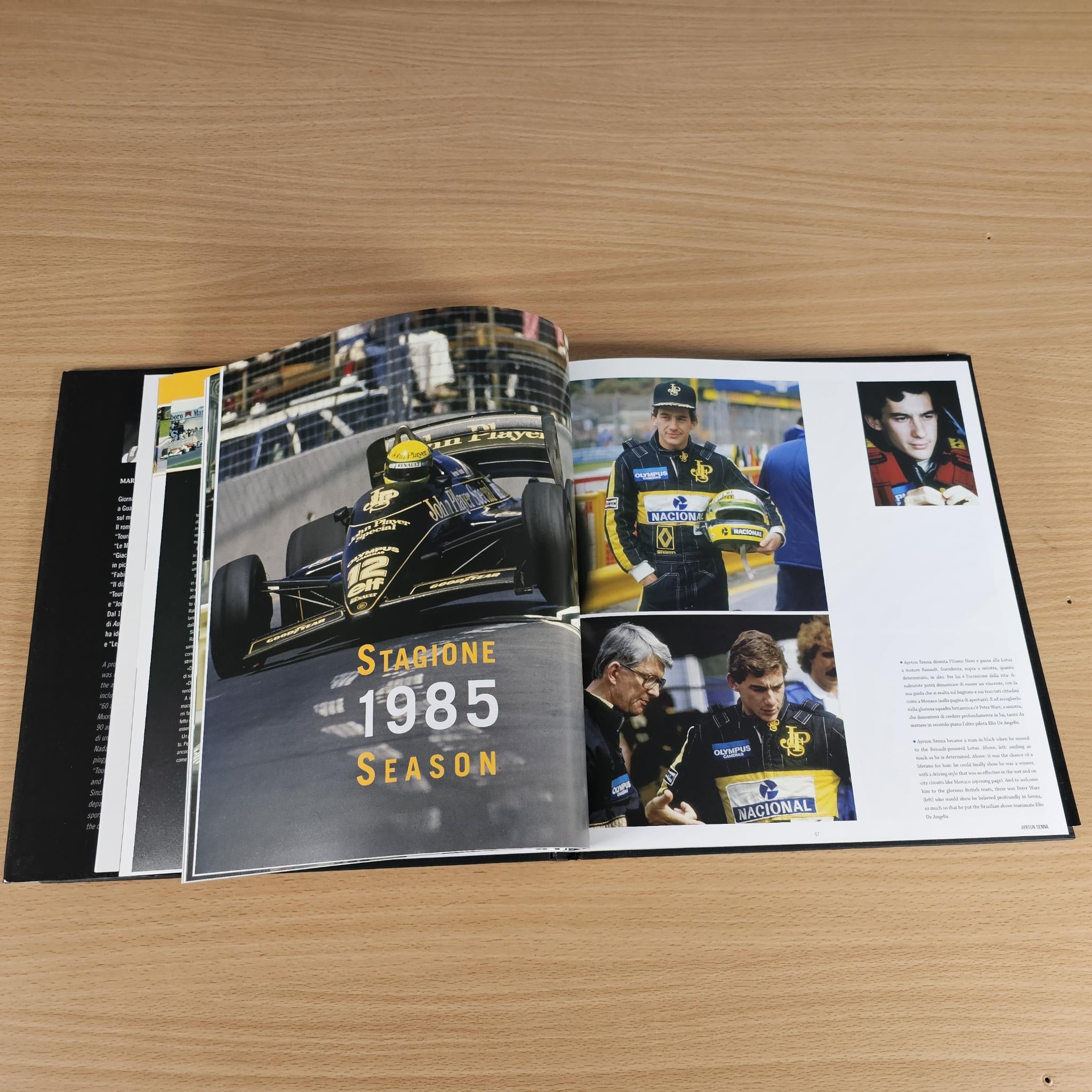 Open hardcover photo book with bold yellow 'Stagione 1985' and racing team images