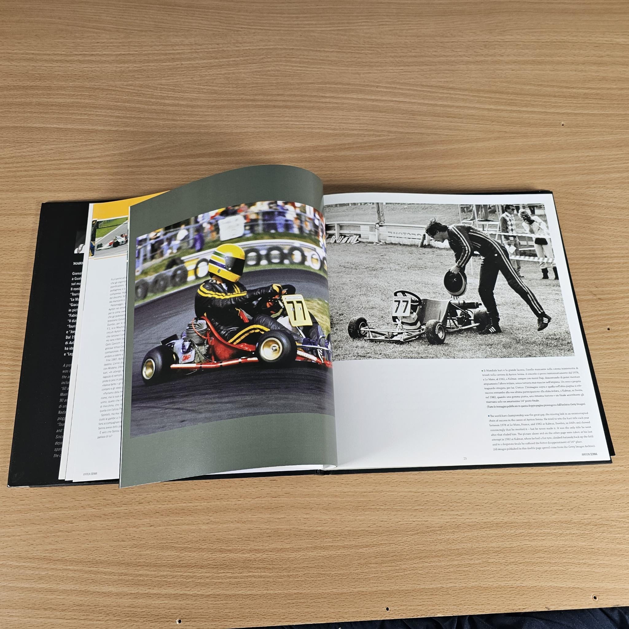 Open hardcover photo book with motorsport action photos and printed explanatory text