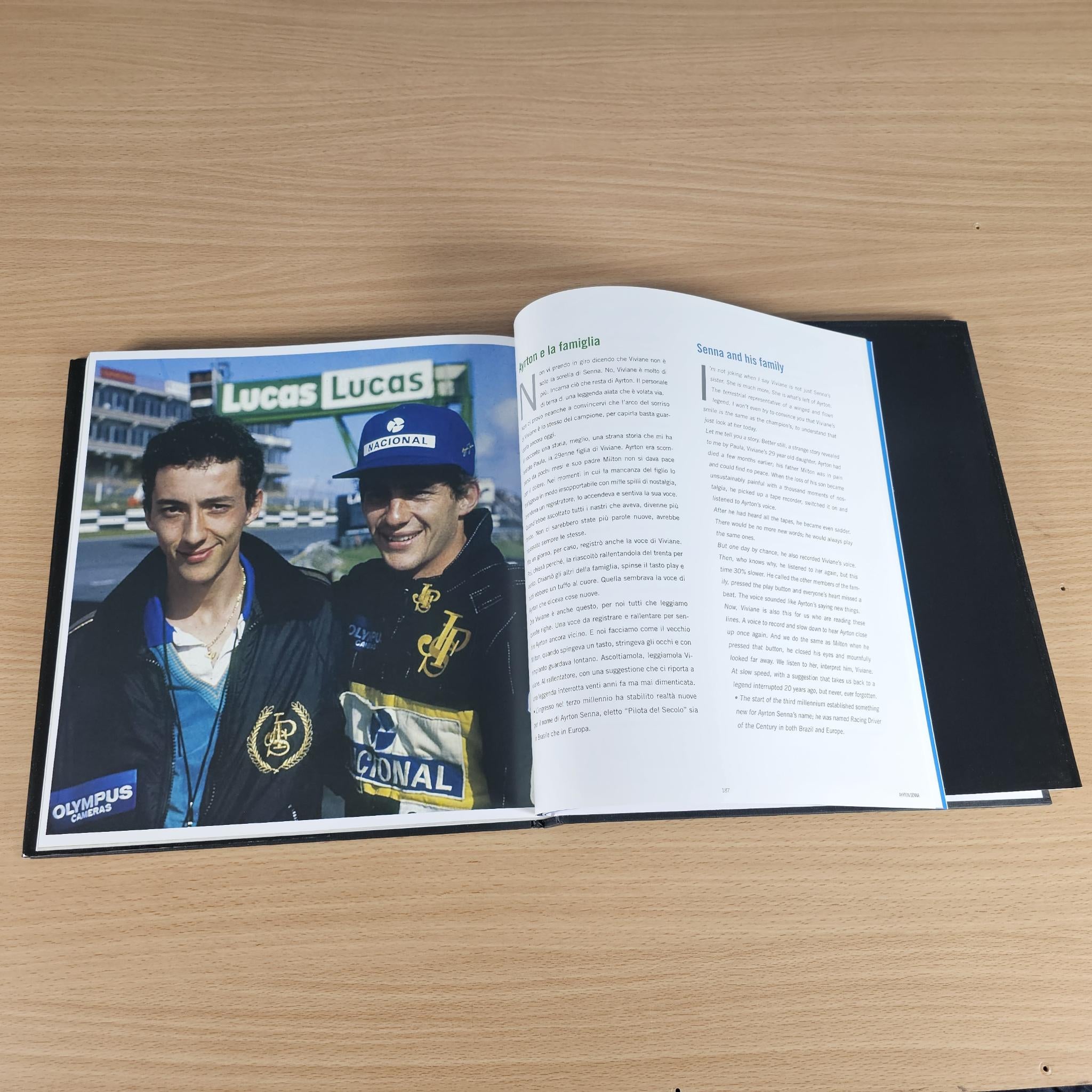 Open hardcover photo book with two men portrait photos and printed article text