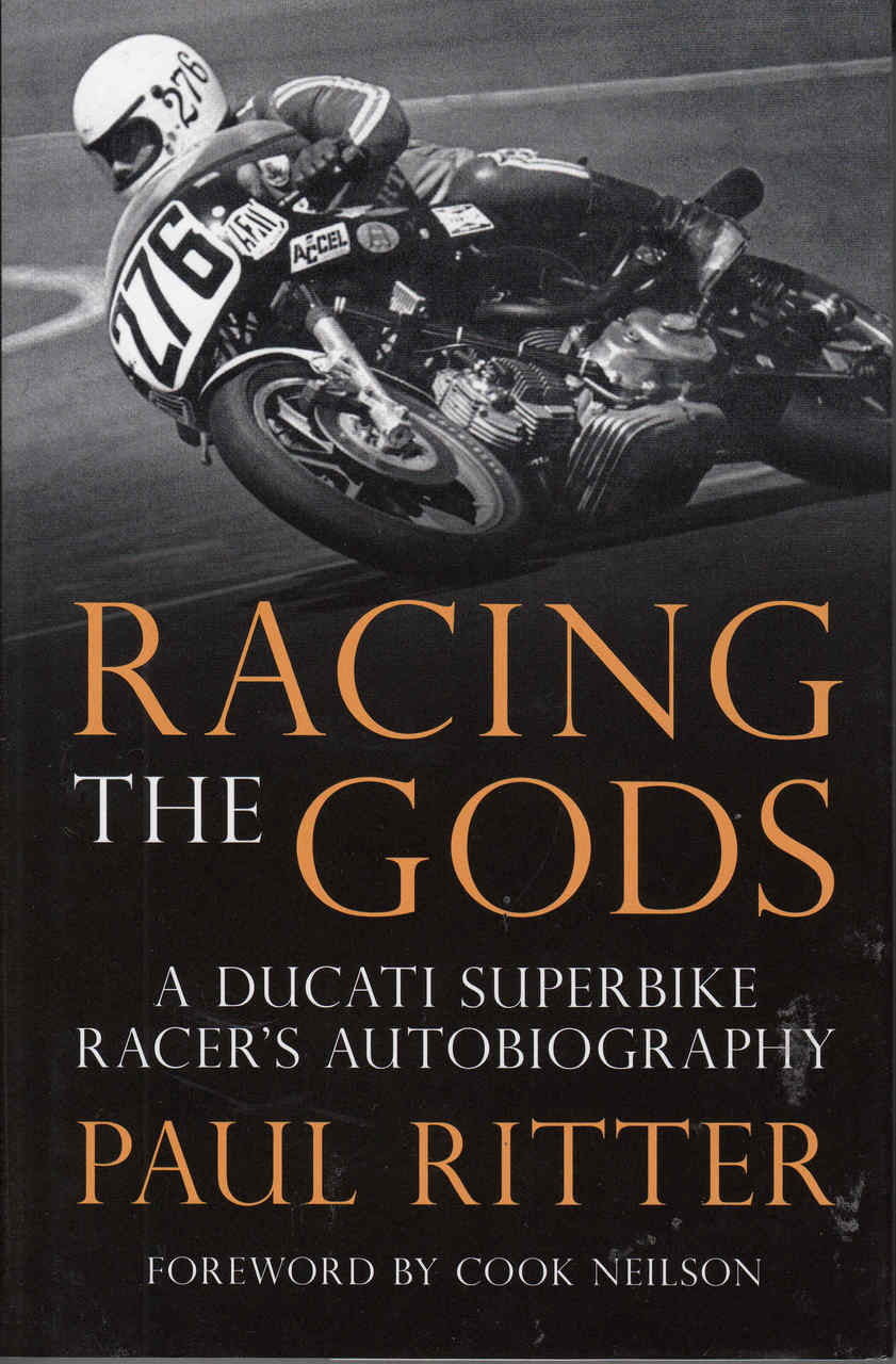 Autobiography book cover with black racing motorcycle and gold title 'Racing the Gods'