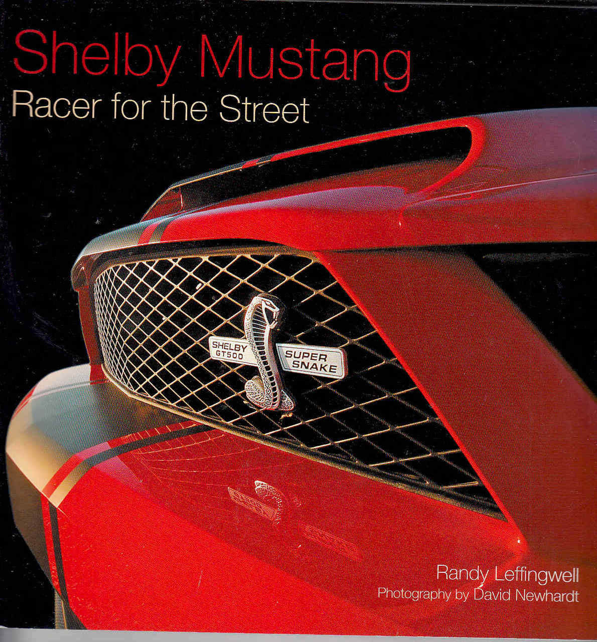 Softcover auto book cover closeup with Shelby Mustang red title and red grille car