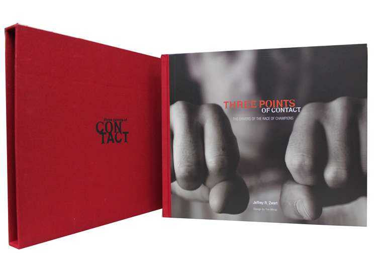 Signed photo book with red cover and open black-and-white hands photo