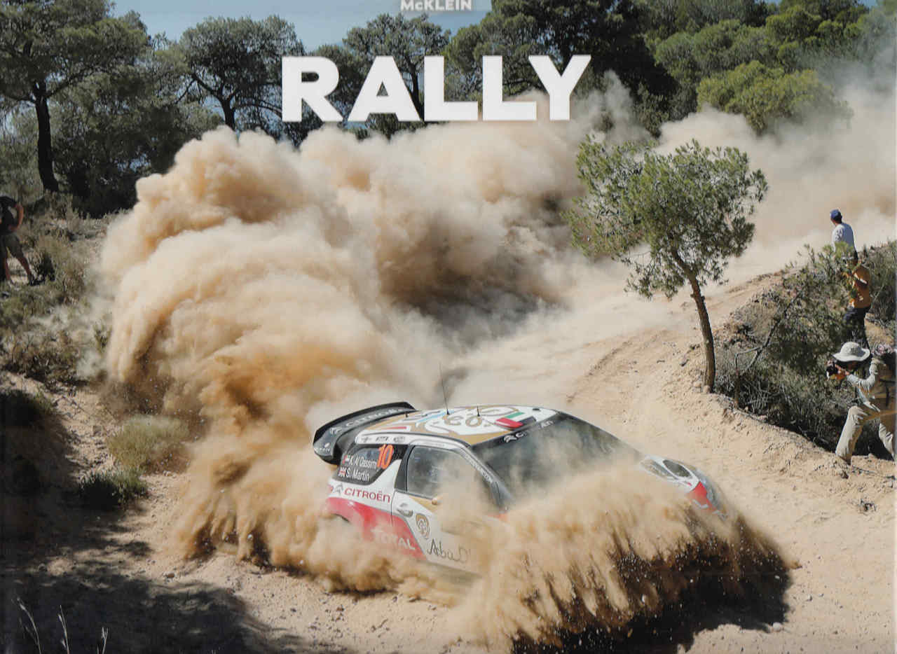 Rally car with large dust cloud on a dirt track, with “RALLY” title text