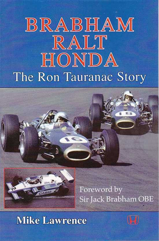 Signed paperback reprint book cover showing open-wheel race cars and title lettering