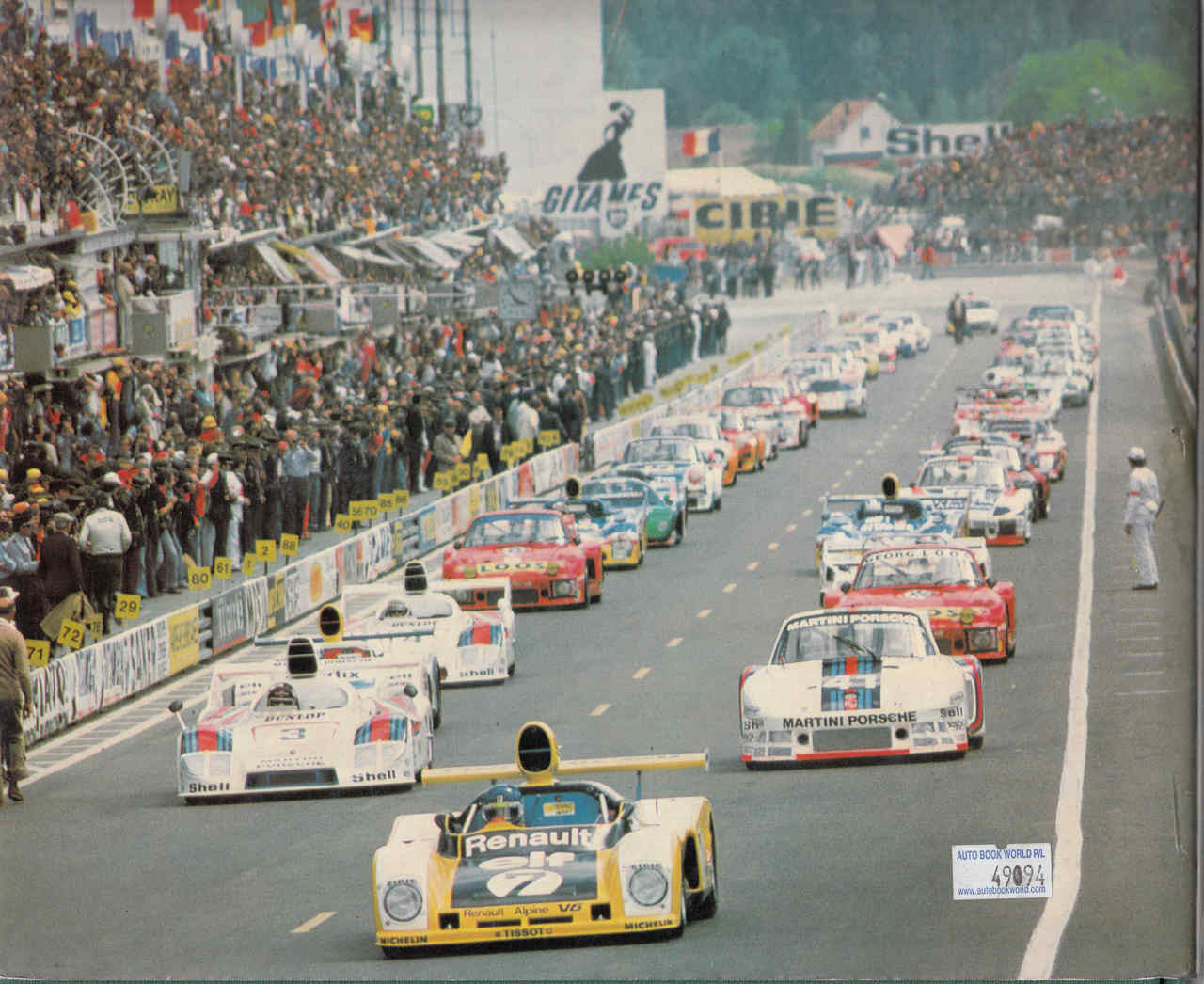 Hardcover book page with vintage race photo and cars lined on a city track.